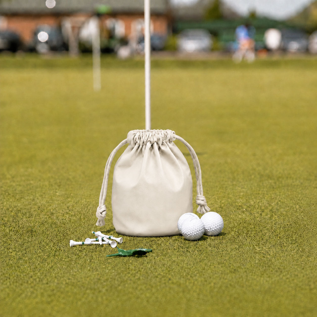 Cream leather golf valuables pouch with drawstring on putting green