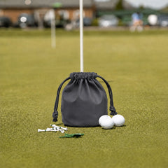 Gray leather golf valuables pouch with drawstring on putting green